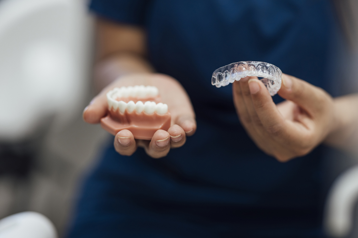 orthodontic expert holding a retainer