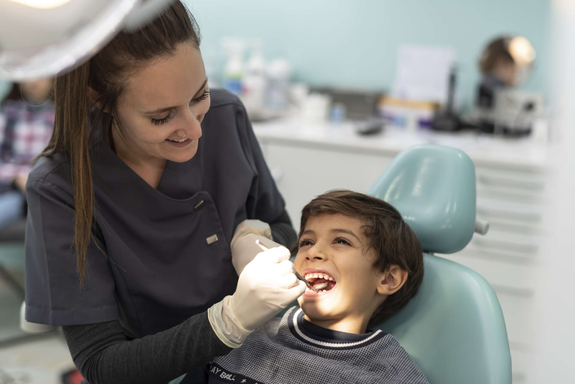 dentist examines a child's mouth in his office